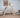 A toddler climbing on a wooden Pikler Triangle in a bright Montessori-style playroom, developing balance and motor skills.
