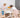 Alt text: Two young children standing on wooden Montessori learning towers while baking together at a kitchen table.