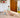 Toddler playing on a wooden Pikler Triangle with a climbing ramp in a bright, modern living room.